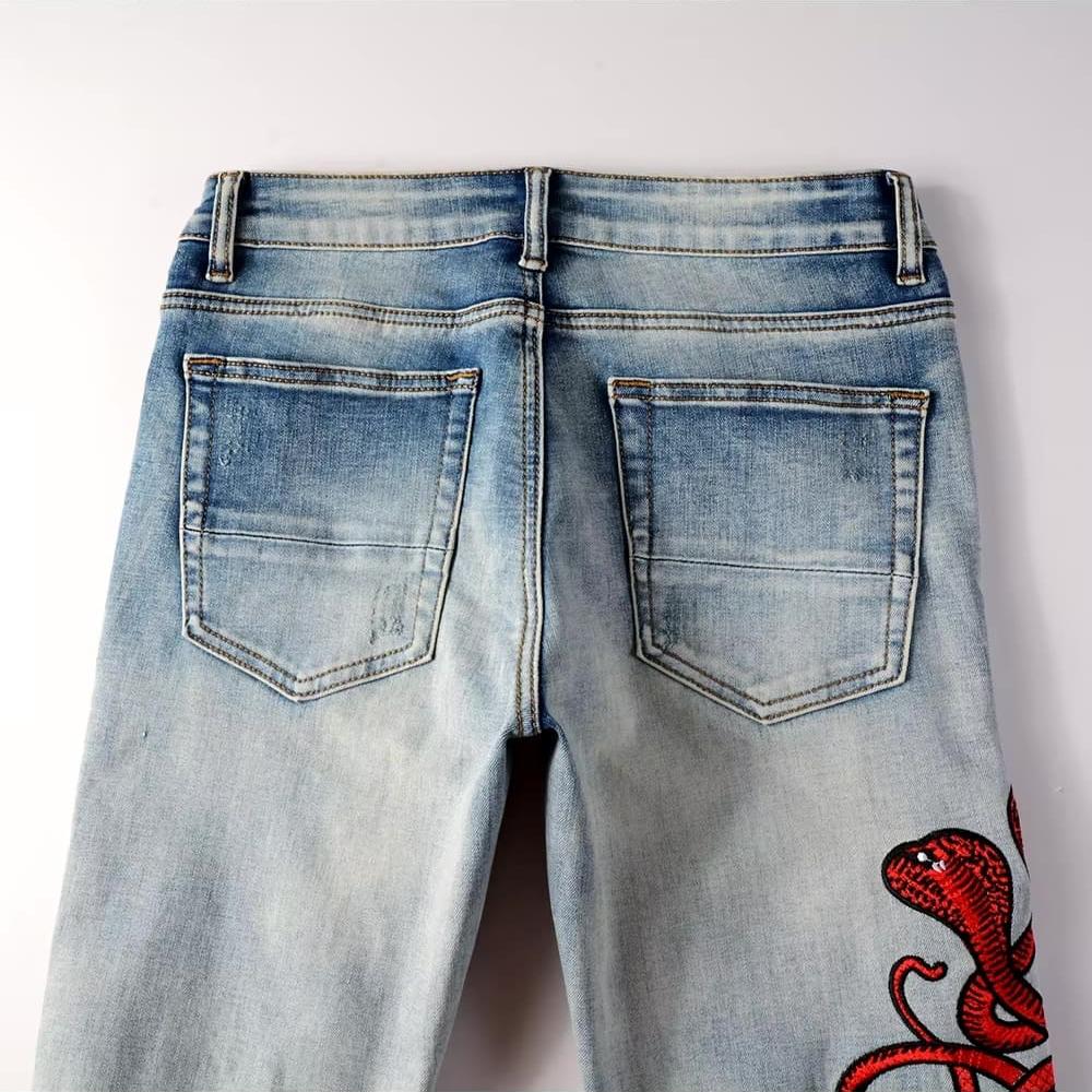 Hellblaue Distressed Jeans mit roter Schlangenstickerei