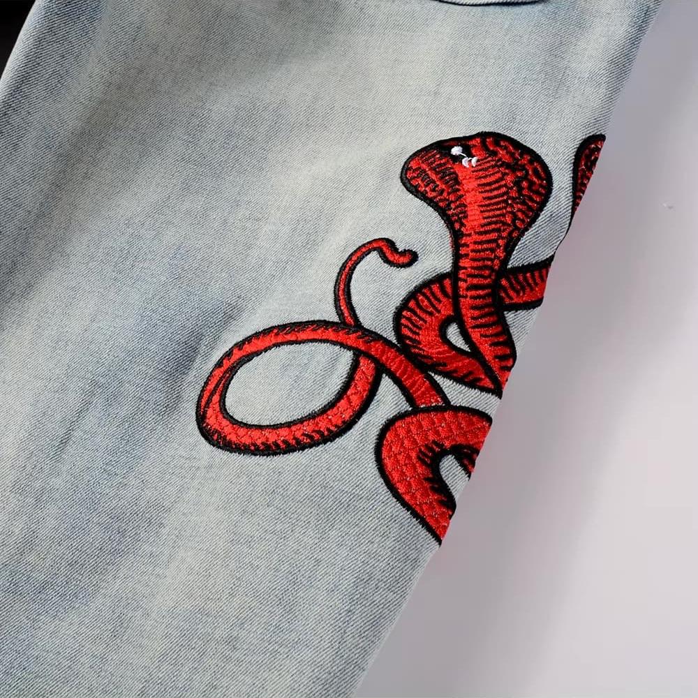 Hellblaue Distressed Jeans mit roter Schlangenstickerei