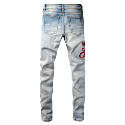 Hellblaue Distressed Jeans mit roter Schlangenstickerei