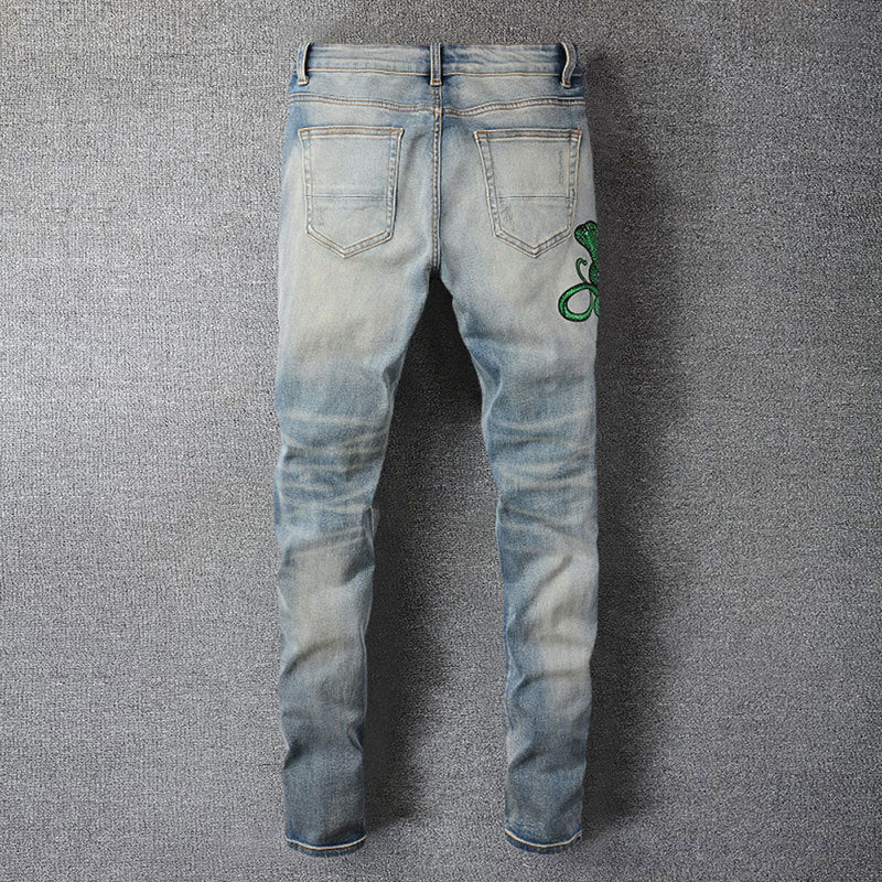 Hellblaue Distressed Jeans mit grüner Schlangenstickerei