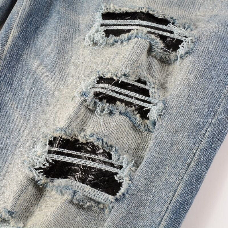 Hellblaue Distressed Jeans mit grüner Schlangenstickerei